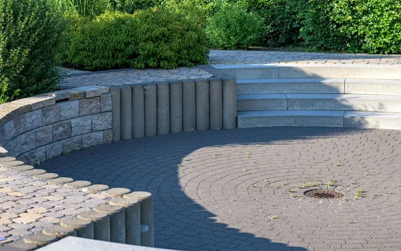 Paved outdoor seating area beside a garden